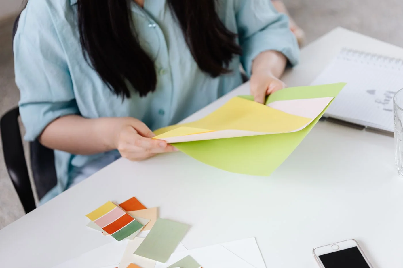 A designer comparing paper colour samples