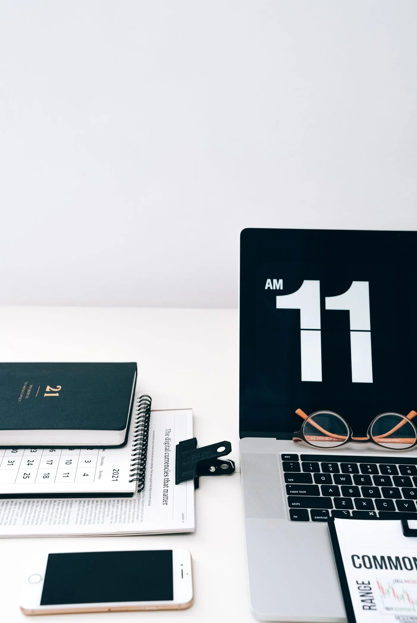 A calendar and digital clock beside a laptop