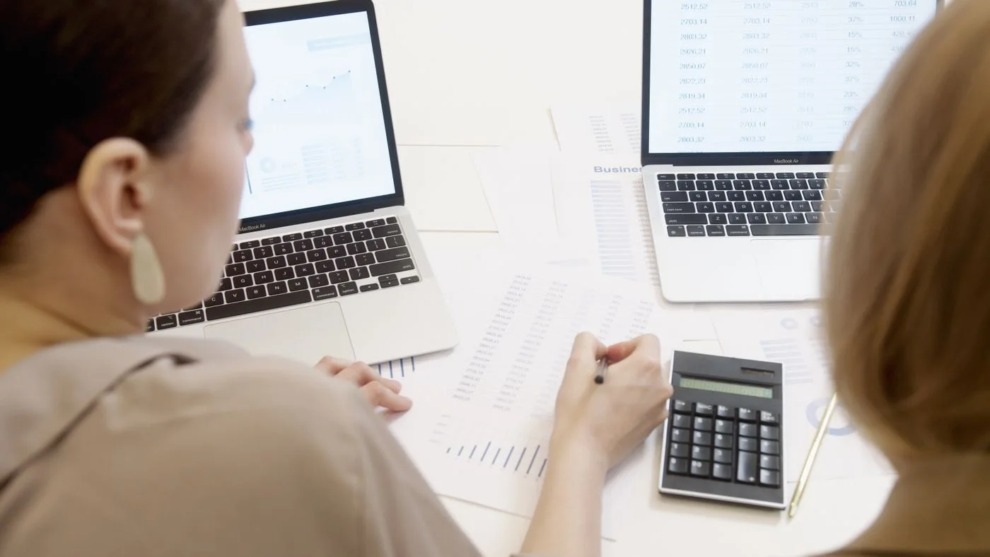 People examining dashboard reports on laptops
