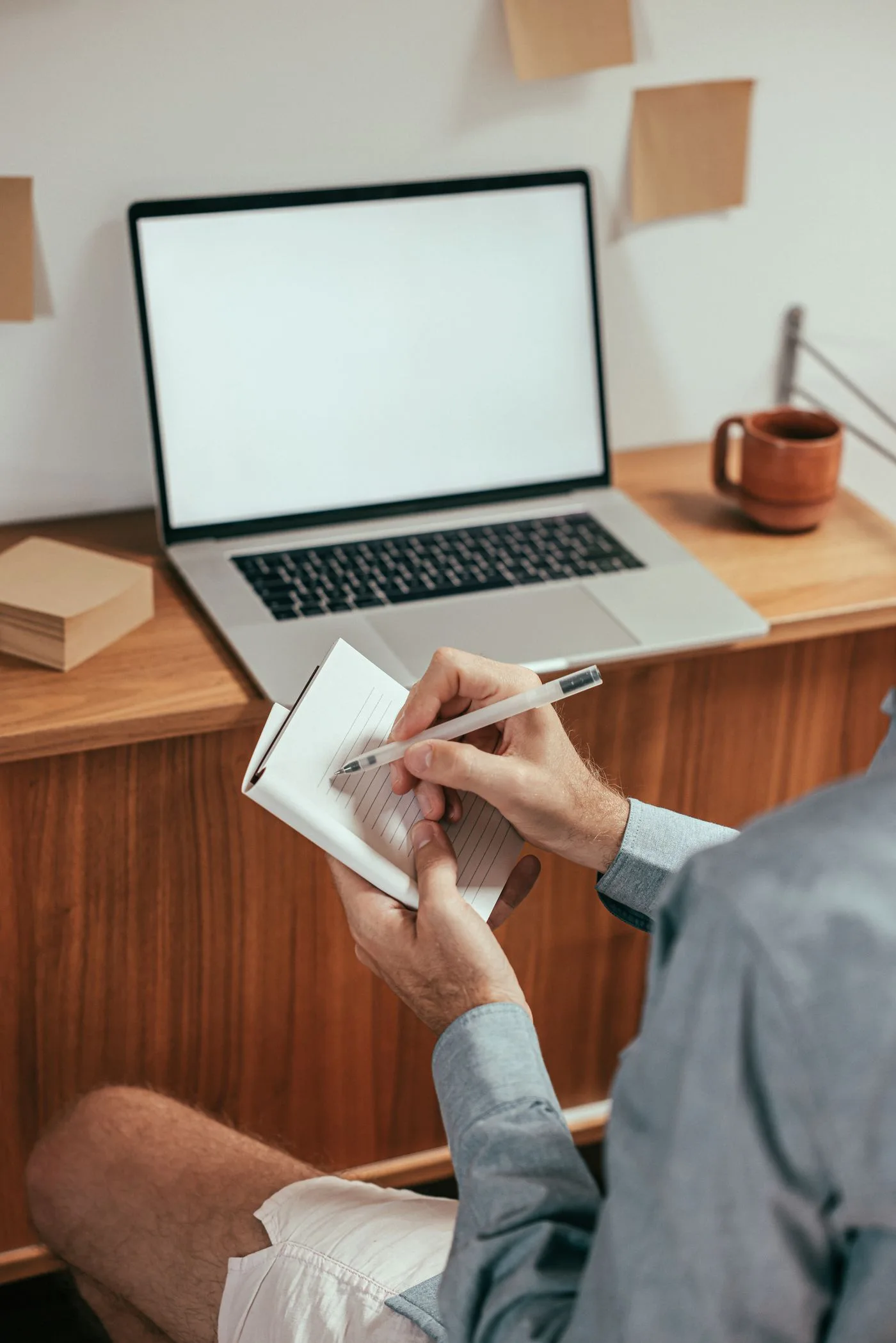 Writing notes beside a laptop