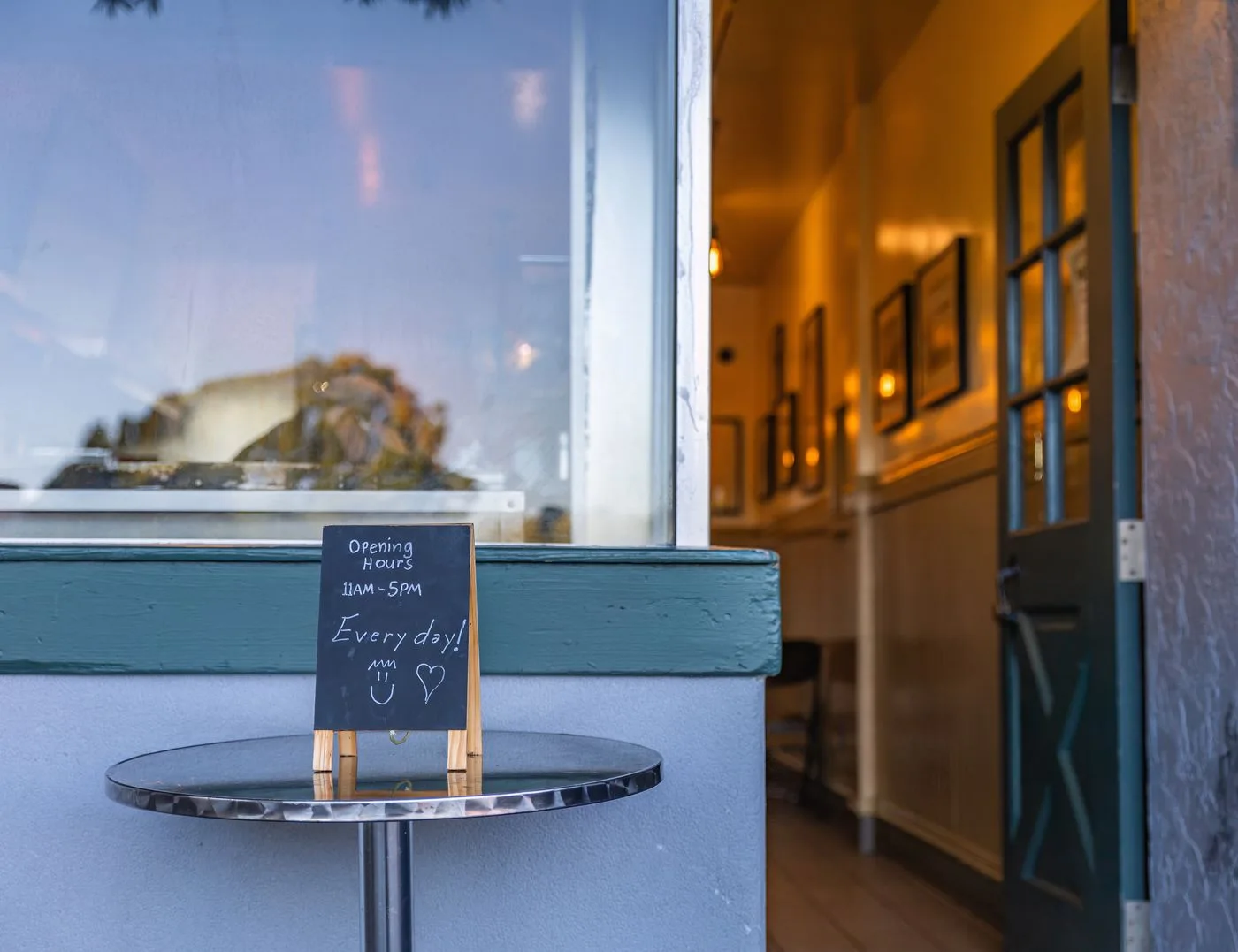 A café entrance with opening hours