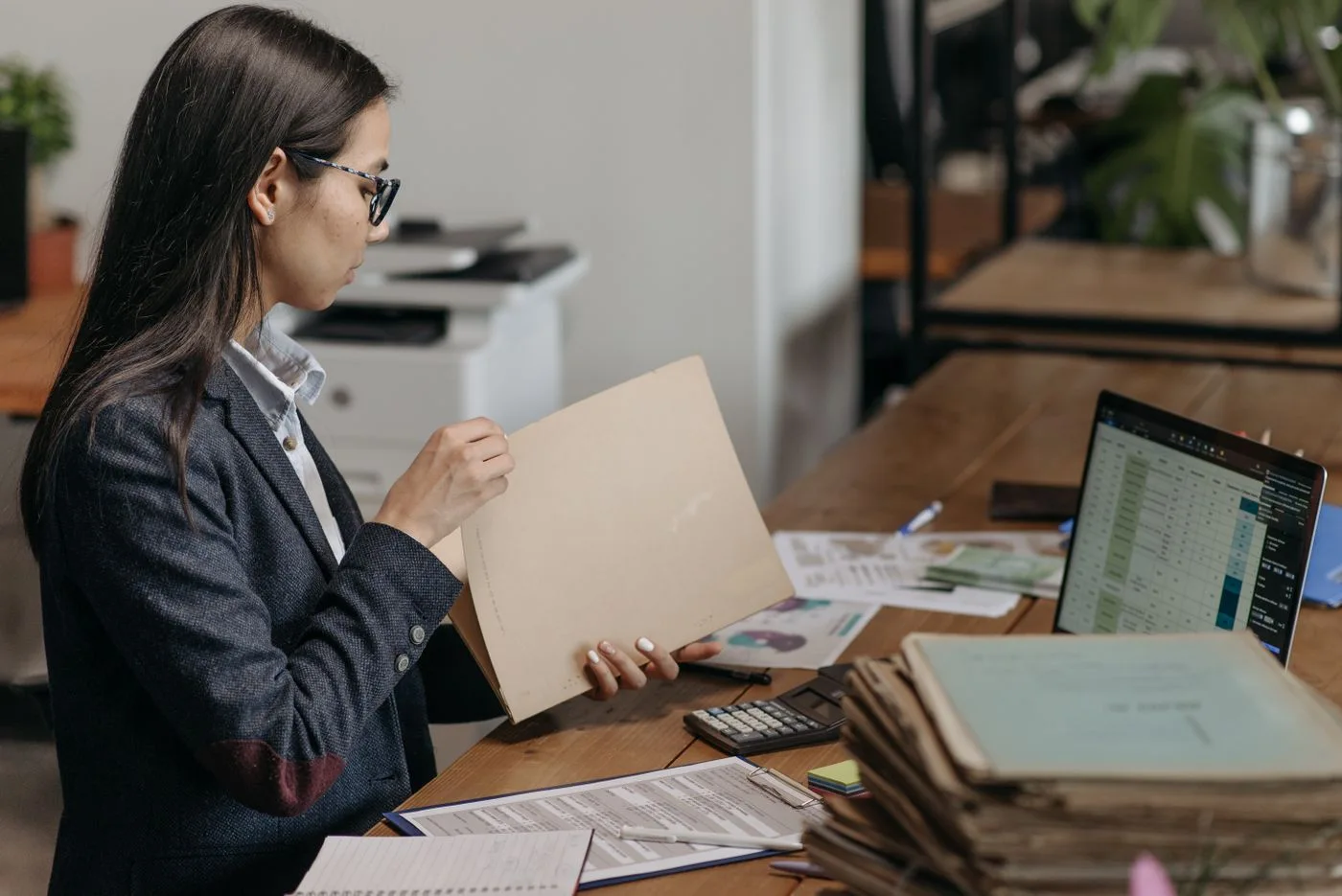 Reviewing a document folder beside a laptop