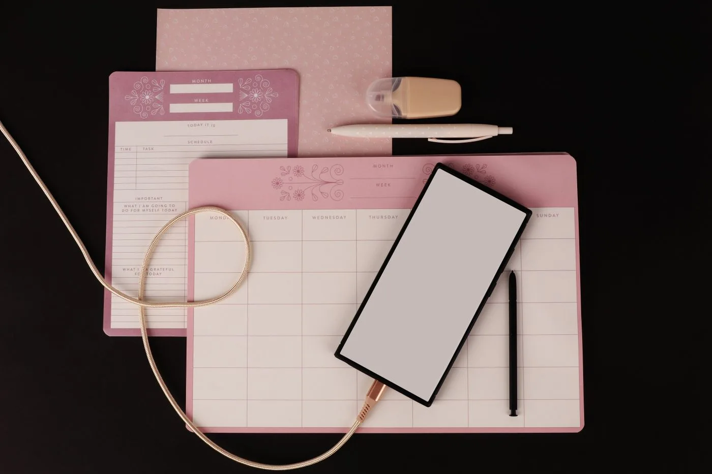 A planner, tablet and stationery on a desk