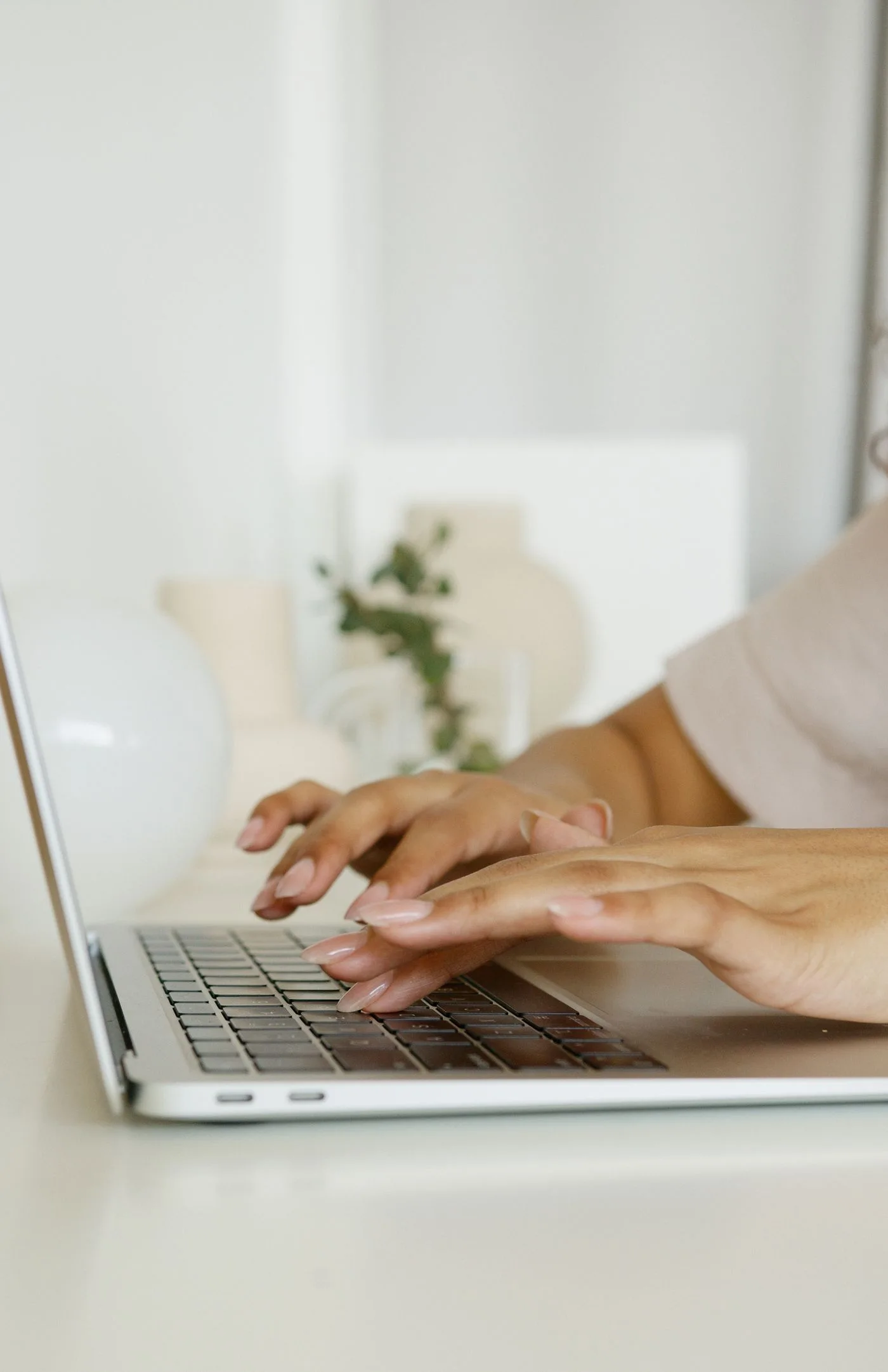Hands typing on a laptop keyboard