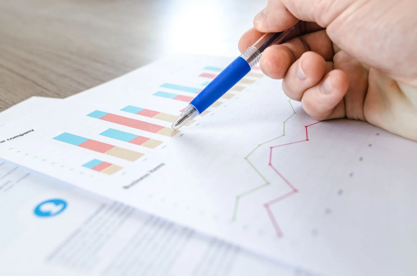 A pen pointing at printed bar charts