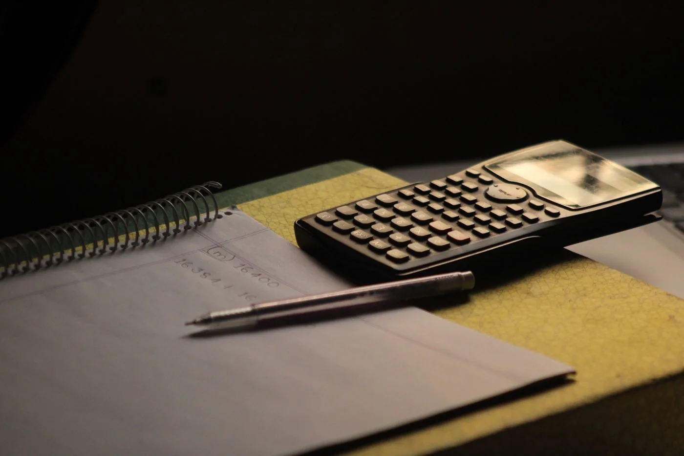 A calculator beside an open notebook